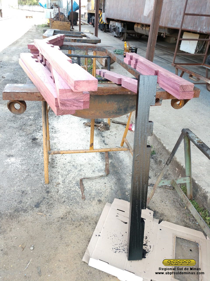 As novas peças de madeira recebendo pintura para proteção.